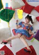 A woman in a red, white and blue polka dot dress laying on a couch.