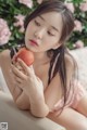 A woman sitting on a couch holding an apple.