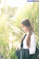 A woman standing in a field of tall grass.