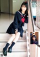 A woman in a school uniform is sitting on the stairs.