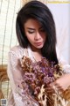 A woman holding a bunch of dried flowers in her hands.