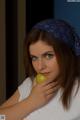 A woman with a bandana on her head holding an apple.